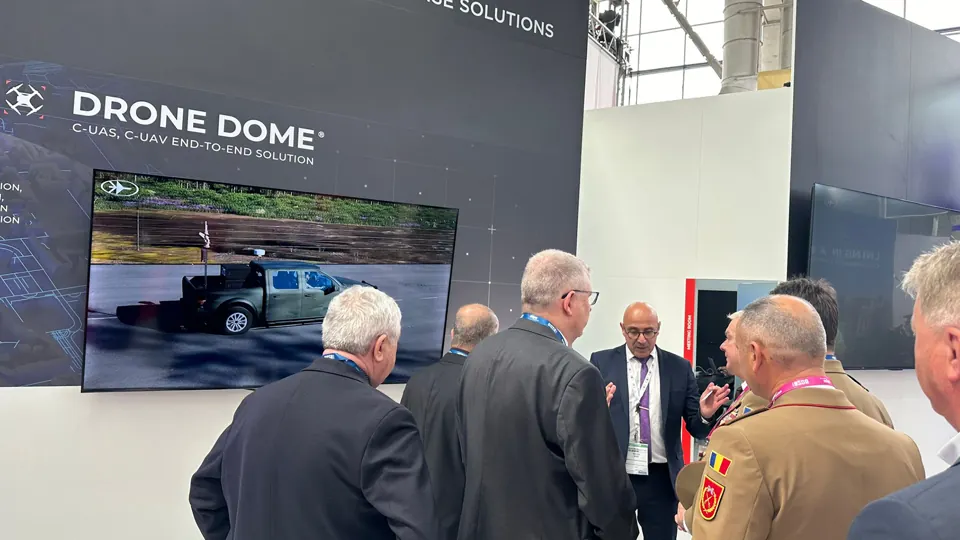 Drone Dome demonstration - Visitors gather around the exhibition screen and equipment.