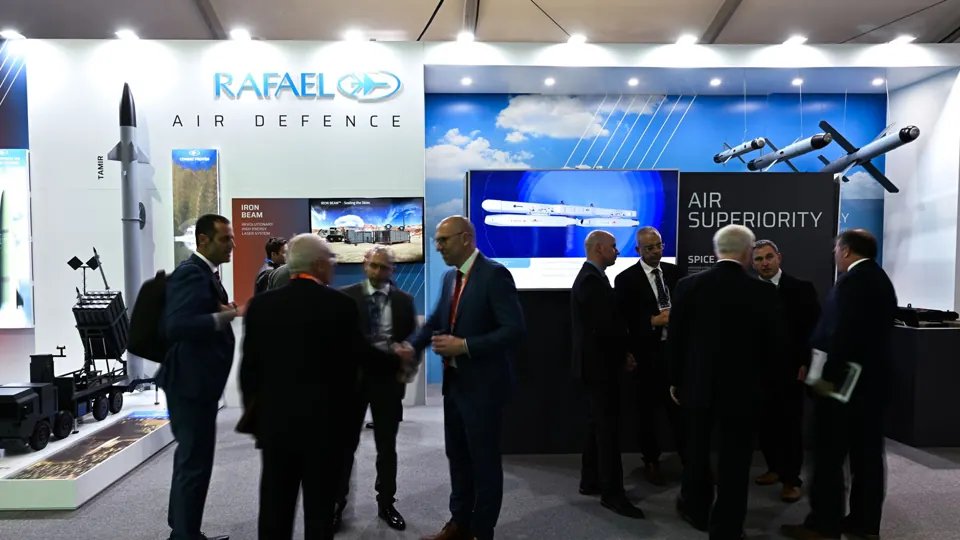 Exhibition overview - Visitors at the RAFAEL stand beneath large presentation screens.