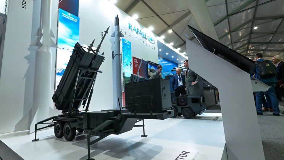 Equipment display - Physical exhibits line the stand beside digital content.